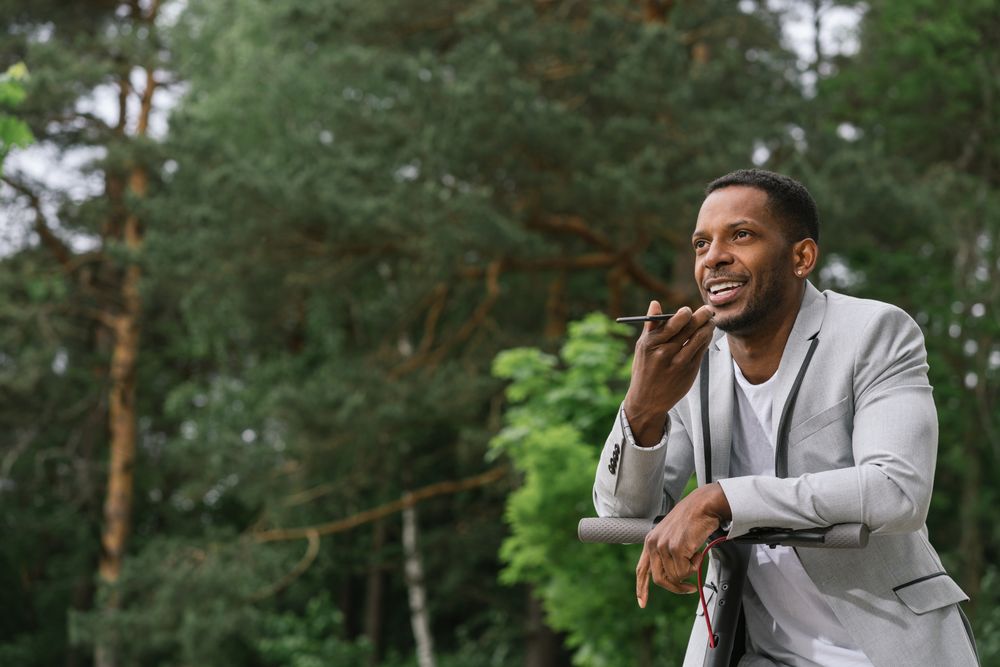 Black man on scooter talking on smartphone