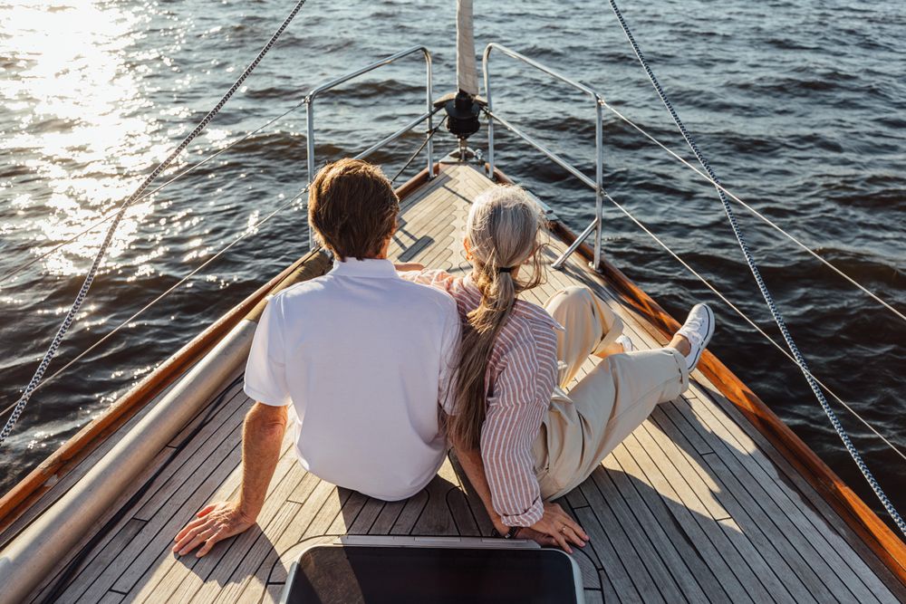 Rearview of two mature people sitting on a yacht bow