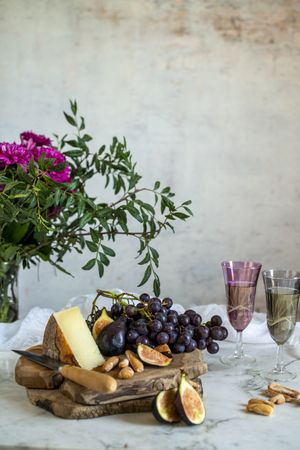 apes next to piece of cheese on cutting boards near pink flowers