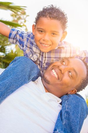 Son and Father Playing Piggyback Outdoors Together.