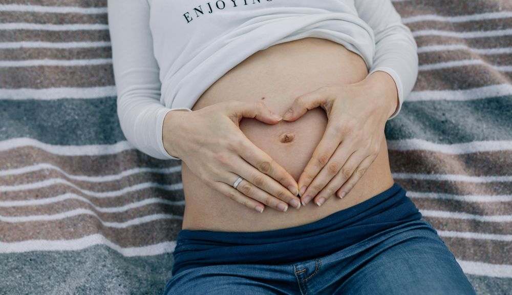 Woman's pregnant belly lying on a blanket