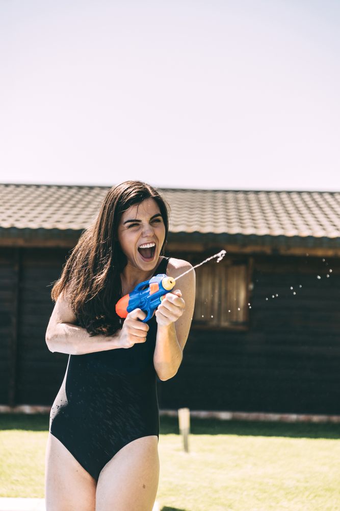 Woman aiming with water-pistol
