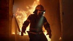 Firefighter running away from fire