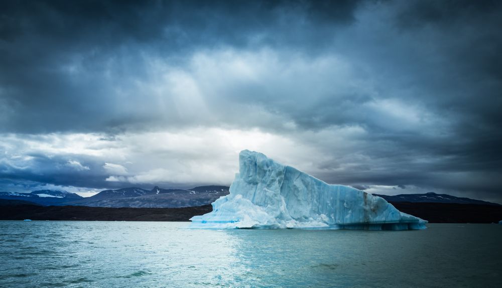 Iceberg against overcast sky