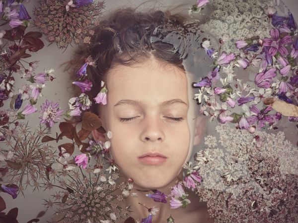 Boy in bath with colorful flowers