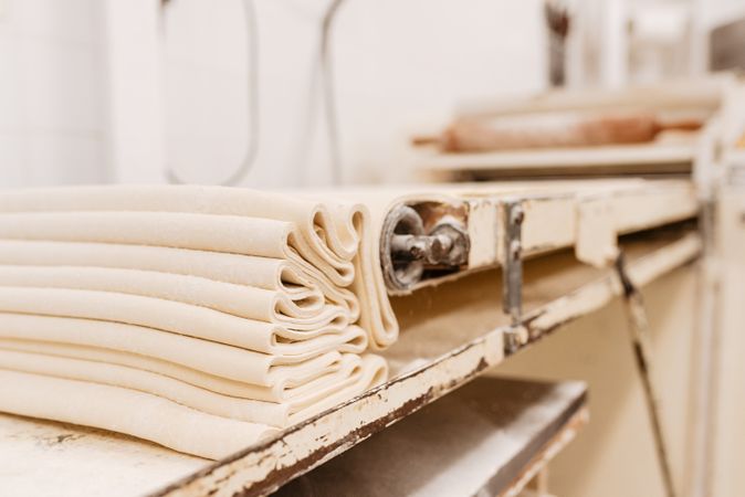 Professional machine rolling dough in bakery