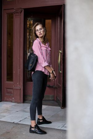 Woman in smart casual wear standing outside of a door