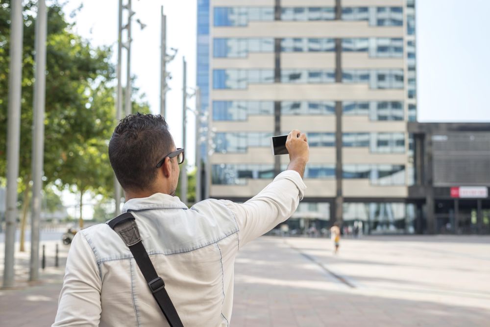 Rear shot of male taking selfie outside