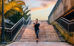 Female runner training on stairs at dusk