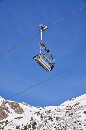 Ropeway in snowy mountains on cloudless day