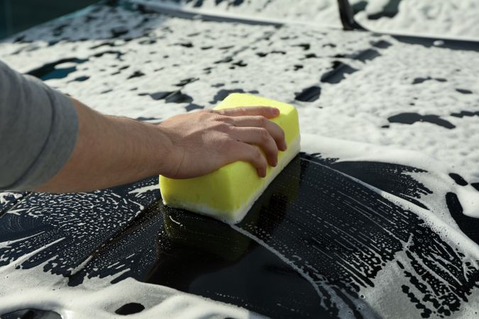 Man wipes the car with a sponge. Car wash. Clear car concept