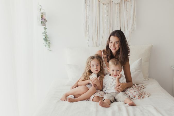 Content young mother with little kids at bedroom