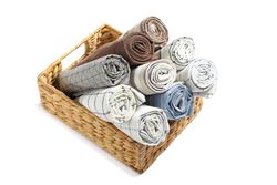 Rolled up fabric napkins in basket isolated on plain background