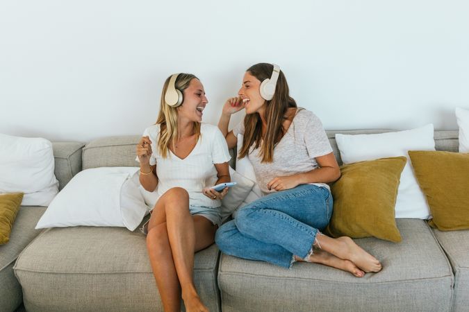 Delighted women singing on couch