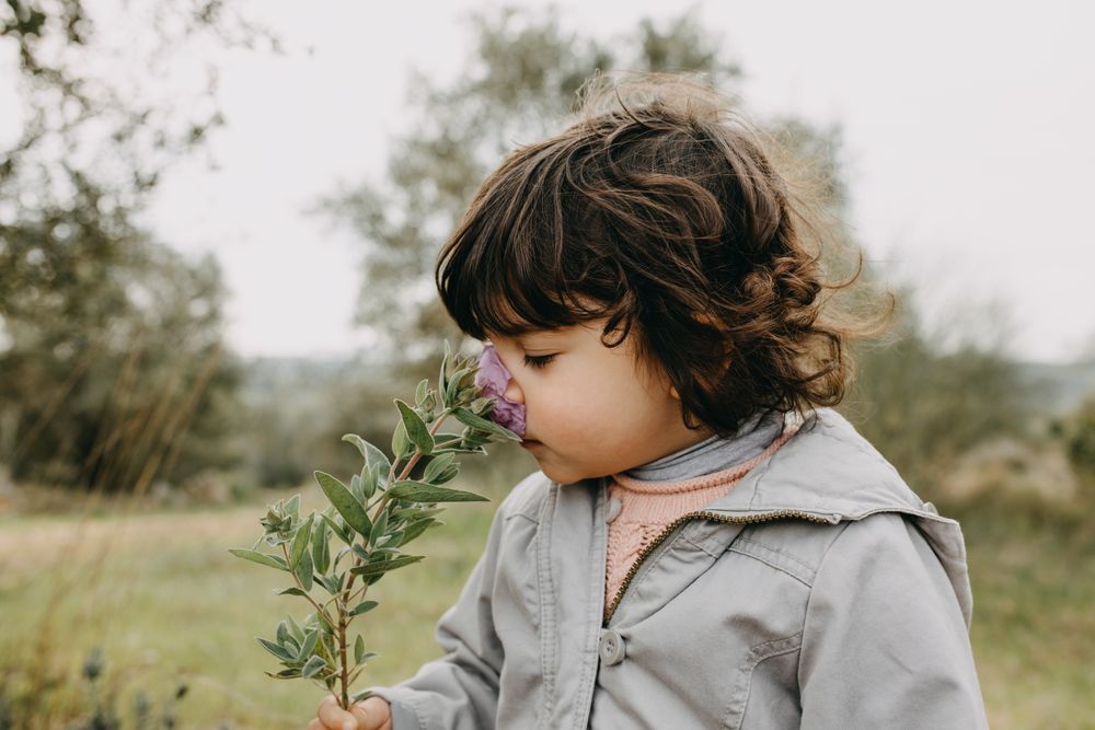 Girl smelling a flower outside