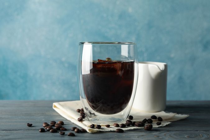 Composition with glass of ice coffee on wooden background