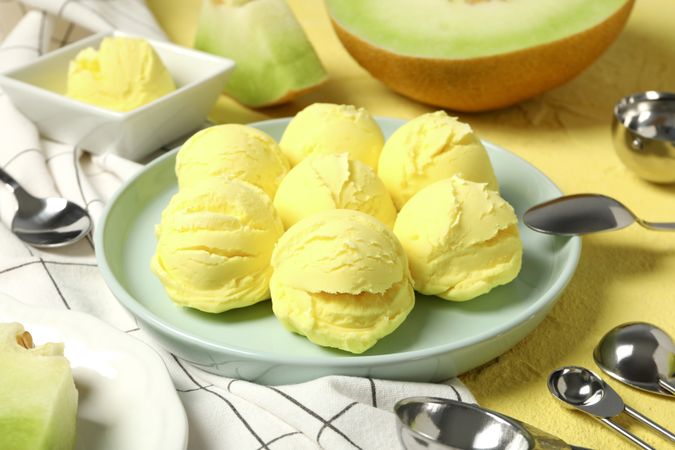 Ice cream scoops in a bowl with slices of fresh melon