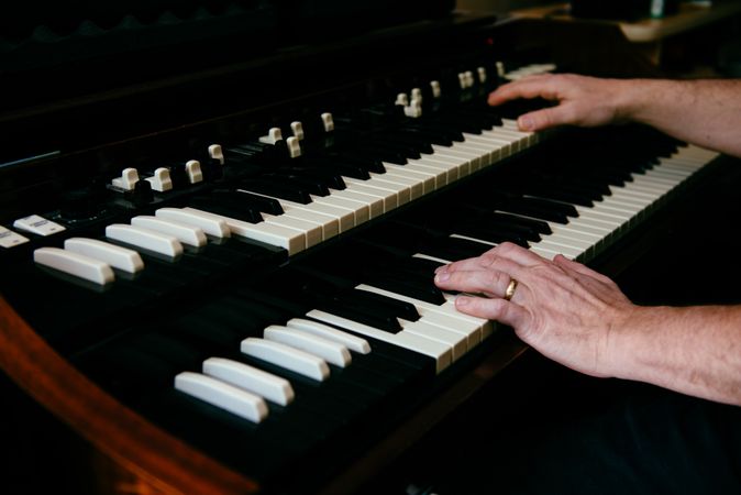 Man's hands playing a double keyboard organ