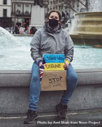 London, England, United Kingdom - March 5 2022: Woman sitting at fountain with anti war sign 0WdNW5