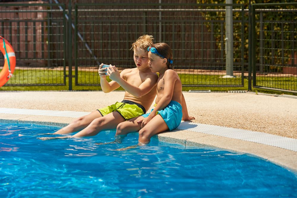 Boys on poolside taking selfie