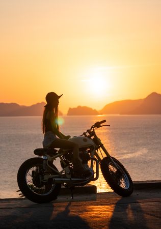 Woman with motorbike near sea