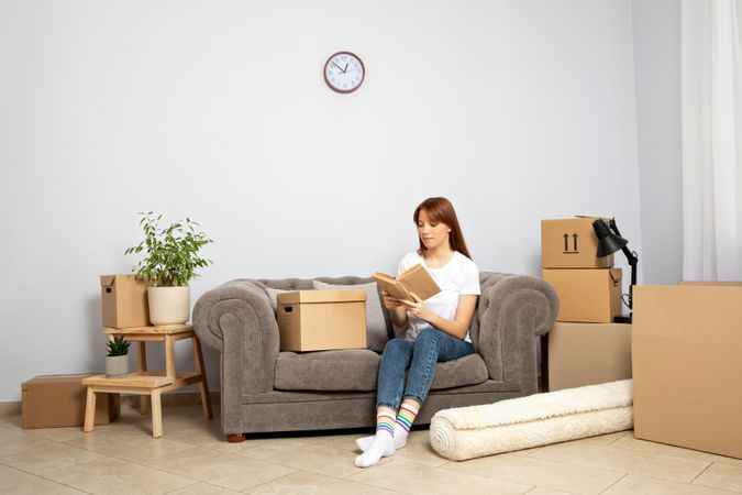 The concept of moving, a woman with boxes in an apartment.