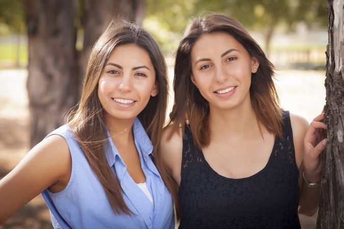 Two Twin Sisters Standing In Park
