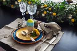 Easter table setting with eggs on table with lush centerpiece
