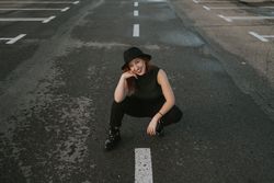 Smiling woman sitting on road with markings