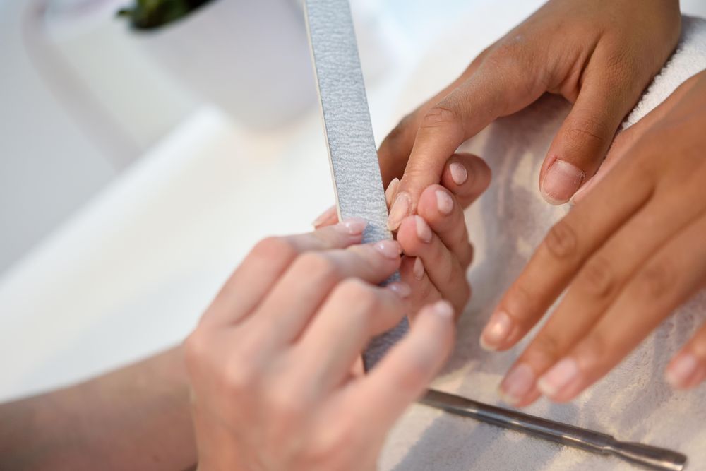 Close up of woman filing the nails of a client