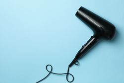 hair dryer on blue background, space for text