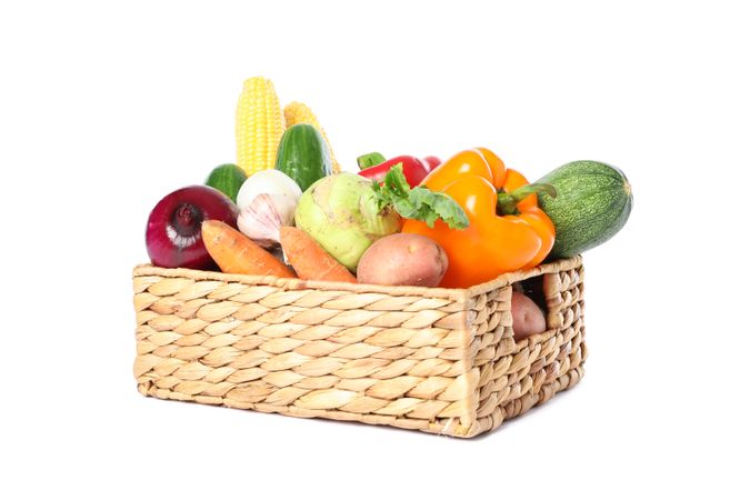 Wicker basket with vegetables isolated on blank background