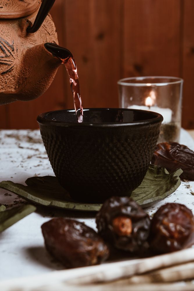 Aromatic tea dates and clay teapot on table
