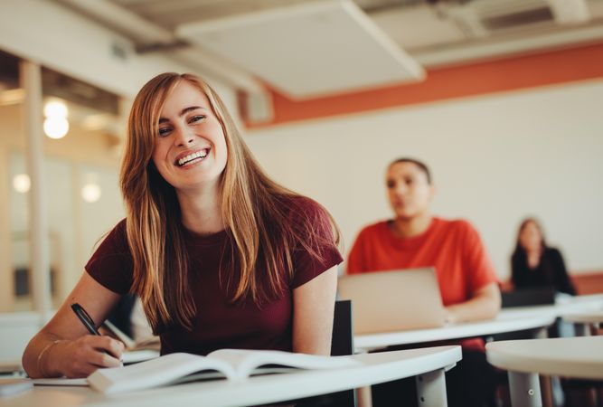 Portrait of beautiful smiling woman in university classroom