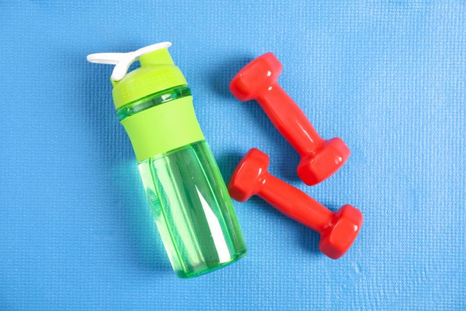 Looking down at green water bottle with red weights