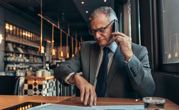Business professional waiting for someone at coffee shop talking over phone