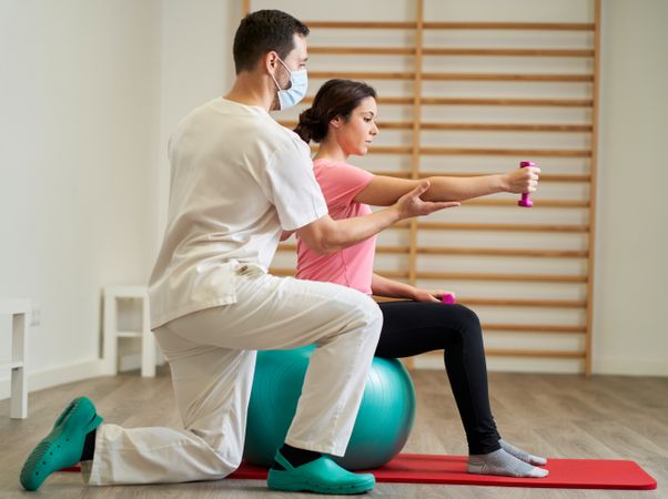 The physiotherapist doing rehabilitation exercises with the pati