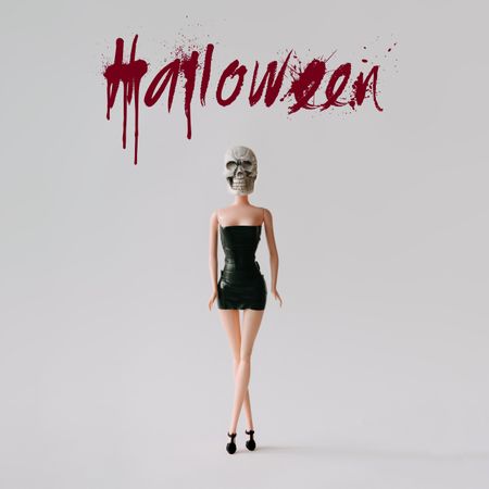 Doll in dress with skull head with “Halloween” text