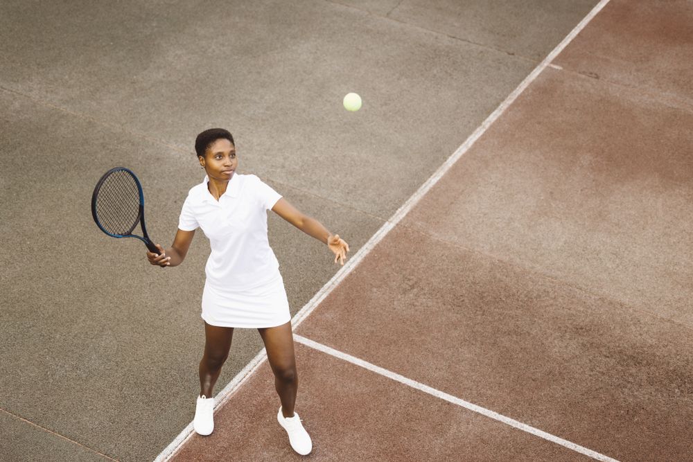 Young woman playing tennis match