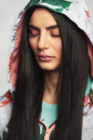 Woman with long brunette hair pictured in colorful printed floral hood