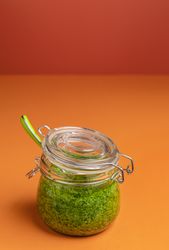 Green pesto sauce in a glass jar