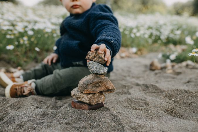 Toddler stacking rocks outside