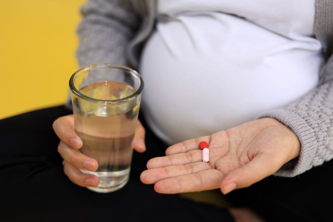Pregnant Woman with Folic Acid Pills and Glass of Water,
