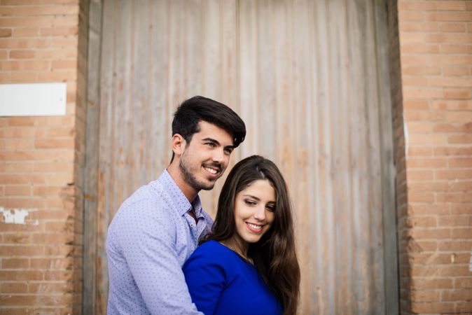 Amorous couple standing near columns