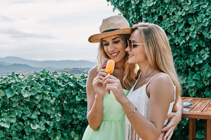 two young women eating ice-cream outdoors