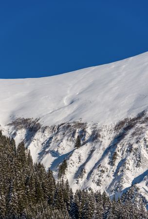 Snow-covered mountain peak against the clear blue sky in Bavaria, Germany