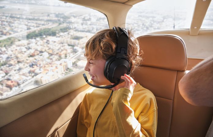 Happy child enjoying city view from plane window during flight o
