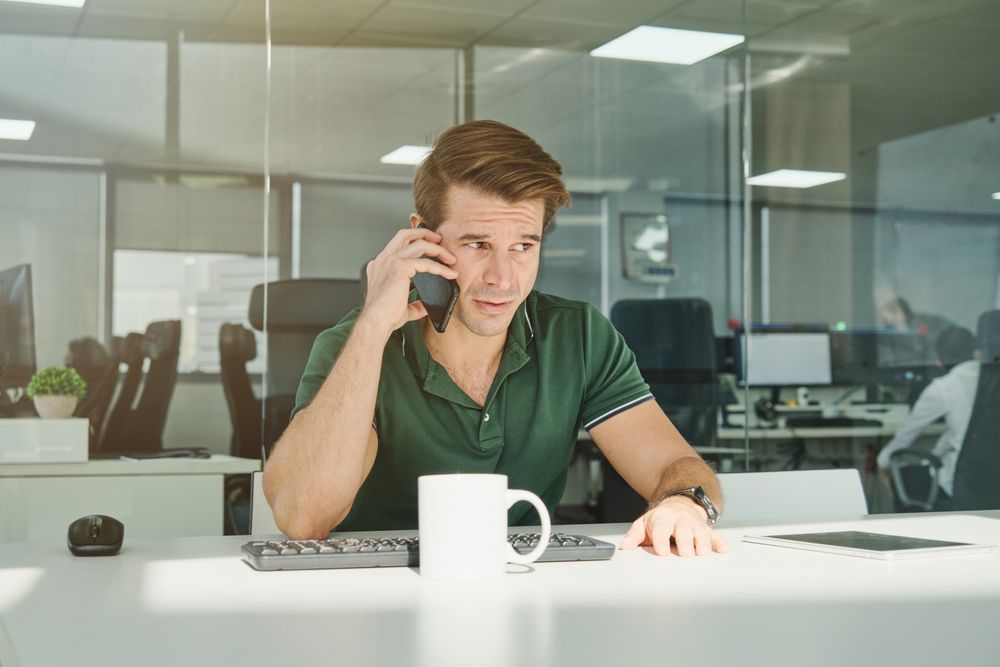 Guy speaking on cellphone in modern office