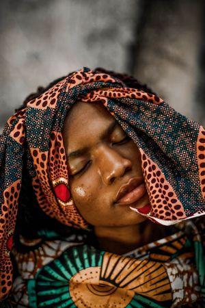 Portrait of woman in colorful headscarf closing her eyes