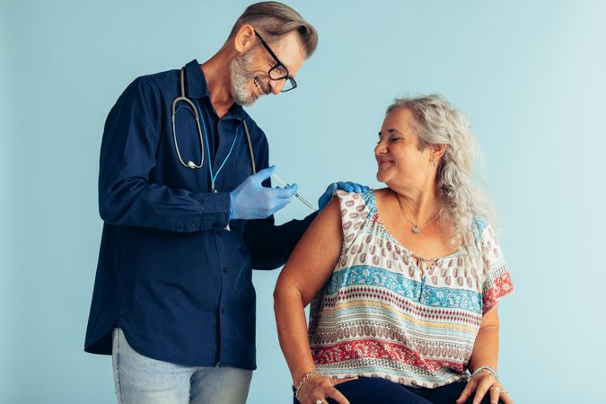 Female getting flu vaccine injection by a medical professional